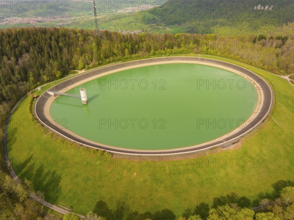 Upper reservoir reservoir on a green hill surrounded by forest and nature, Glems reservoir, Swabian Alb, Germany