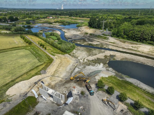 Dortmund, Castrop-Rauxel, North Rhine-Westphalia, Germany - River renaturalisation, renaturation of the Emscher, flood retention basin HRB Mengede. A new floodplain landscape is being created at the Emscher-Auen farm, expanding the area for flood protection during heavy rainfall and for biodiversity. The previously straightened Emscher is being given curves again and can meander through its new floodplain. Following the construction of a parallel sewer, the Emscher has been completely free of sewage since 2022. The river was previously an open, above-ground combined sewer with rainwater and wastewater. Heimanngraben inlet at the front, construction of a bridge over the ditch