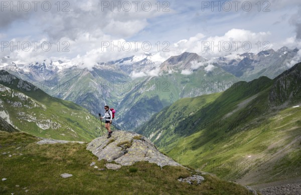 Mountaineer on a rock at the Mittagskögele, view of mountain peaks of the Venediger group and the Lasnitzental valley, Lasörling Höhenweg, Lasörling group, Hohe Tauern National Park, East Tyrol, Tyrol, Austria