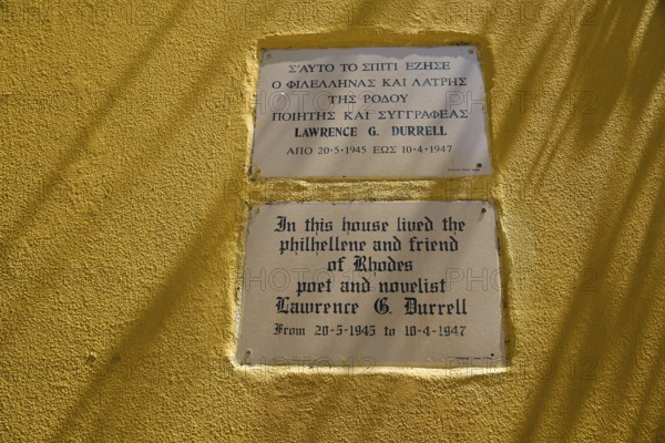 House of Lawrence Durrell, memorial plaques on a yellow wall with quotes by Lawrence G. Durrell, harbour area, Rhodes Town, Rhodes, Dodecanese, Greek Islands, Greece
