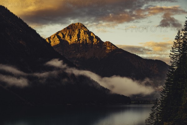 Sunrise with reflections and alpenglow in Lake Heiterwanger See in Tyrol in the Alps in Austria