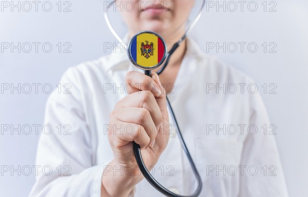 Female doctor holding stethoscope with Moldova flag. National health system of Moldova