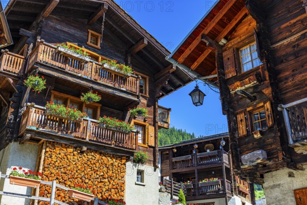 Old wooden houses in log construction, decorated with flowers, historic village centre, Grimentz, Val d'Anniviers, Valais Alps, Canton Valais, Switzerland