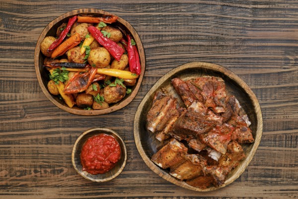 Succulent short beef ribs roasted in the oven served alongside a medley of grilled vegetables and a vibrant spicy sauce. This dish highlights rich flavors perfect for a comforting dinner experience