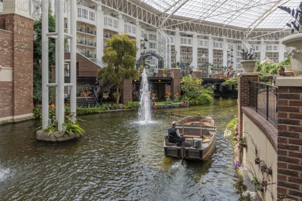 Guide piloting boat through the canal inside the Gaylord Opryland Resort and Convention Center in Nashville, Tennessee