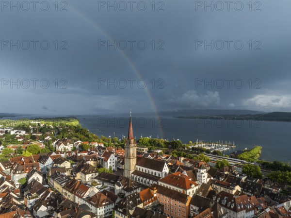 Luftbild von der Stadt Radolfzell am Bodensee mit der historischen Altstadt und dem Radolfzeller Münster nach einem Gewitterschauer von der Abendsonne angestrahlt, am Horizont ein Regenbogen, Landkreis Konstanz, Baden-Württemberg, Deutschland