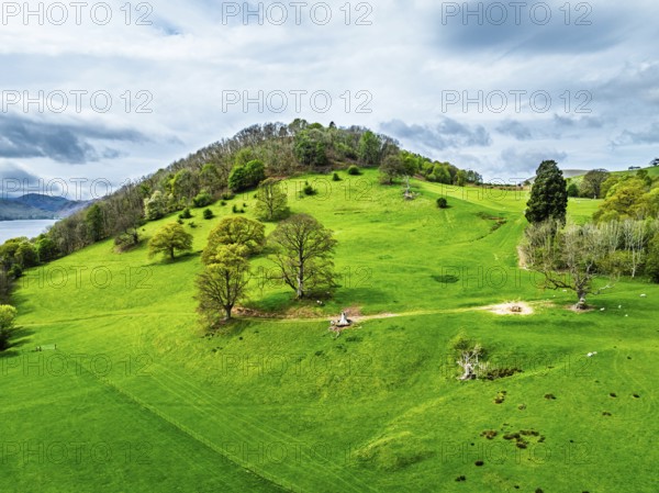 Farms and mountains over Ullswater Lake from drone, Pooley Bridge, Lake District National Park, Cumbria, England, United Kingdom