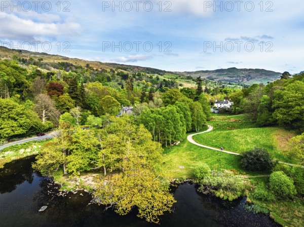 Farms and Mountains over road A591 from a drone, Grasmere Lake, Grasmere, Ambleside, Lake District, Westmorland, Cumbria, UK