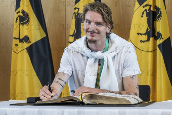 Nick Woltemade signing the Golden Book of the City of Stuttgart. Reception organised by the state capital Stuttgart after VfB Stuttgart's victory in the DFB Cup. Stuttgart, Baden-Württemberg, Germany