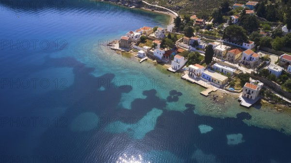 Drone shot, coastal village with white houses on the blue sea and clear coastal landscape, Bay of Emporio, Emporio, Symi, Dodecanese, Greek Islands, Greece