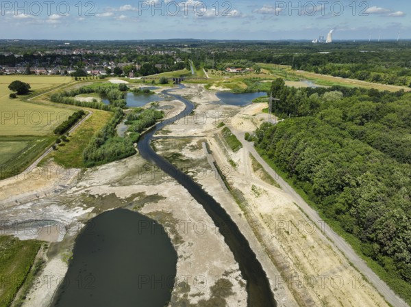 Dortmund, Castrop-Rauxel, North Rhine-Westphalia, Germany - River renaturalisation, renaturation of the Emscher, flood retention basin HRB Mengede. A new floodplain landscape is being created at the Emscher-Auen farm, expanding the area for flood protection during heavy rainfall and for biodiversity. The previously straightened Emscher is being given curves again and can meander through its new floodplain. Following the construction of a parallel sewer, the Emscher has been completely free of sewage since 2022. The river was previously an open, above-ground mixed water channel with rainwater and wastewater. At the back right, the Uniper coal-fired power plant Datteln 4 power station