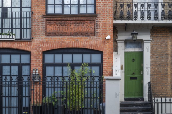Historic brick building labelled Contractors, green door, Kensington, London, England, United Kingdom