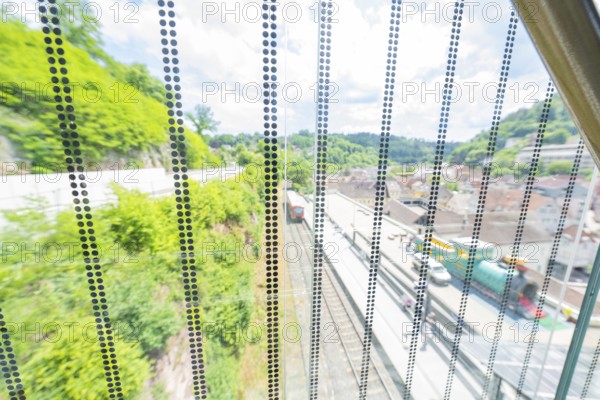 View through a permeable wall of railway tracks and green hills in the background, Zob extension with bridge construction for the new Herman Hesse railway, Calw, Black Forest, Germany