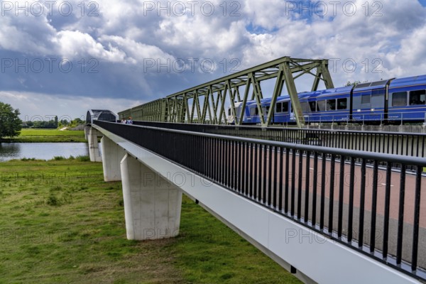De Massover cycle path bridge, over the Meuse south of Nijmegen, near Cuijk, part of the MaasWaalpad long-distance cycle path, 12 km between Nijmegen and Cuijk, built in 2021, for 15 million euros, Meuse river crossing for cyclists and pedestrians, part of a cycle path network, used by many commuters, next to a railway bridge, Netherlands