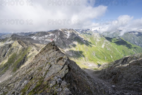 Mountaineer on a steep rocky ridge, on the summit of the Lasörling, view of the mountain panorama of the Venediger Group, Lasörling Group, Hohe Tauern National Park, East Tyrol, Tyrol, Austria