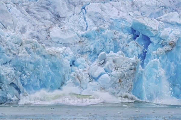 Collapsing ice wall of Fjortende Julibreen, 14th of July Glacier calving into Krossfjorden, Haakon VII Land, Spitsbergen, Svalbard, Norway