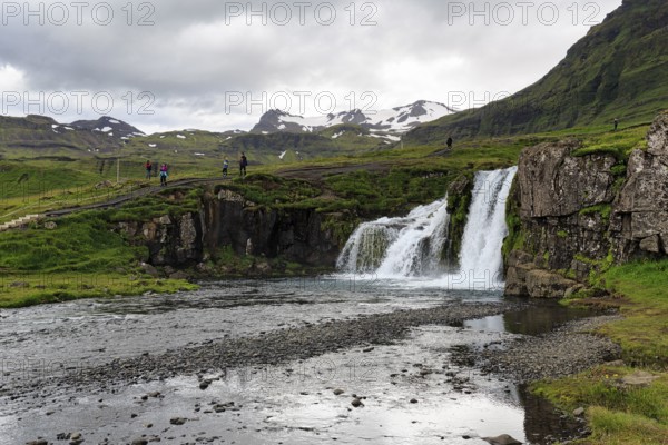 Hikers, tourists at Kirkjufellfoss waterfall, Kirkjufellsa river, Grundarfjördur, Snæfellsnes peninsula, Vesturland, Iceland
