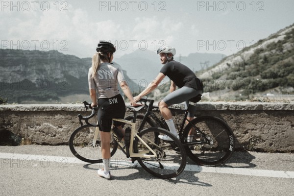 Woman and man cycling on Lake Garda in Italy. Sunny weather and dolce vita