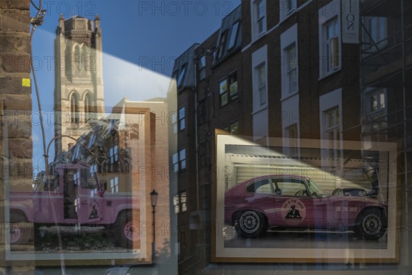 Reflections in a shop window, pink cars and church tower, Portobello Road, Notting Hill, London, England, Great Britain