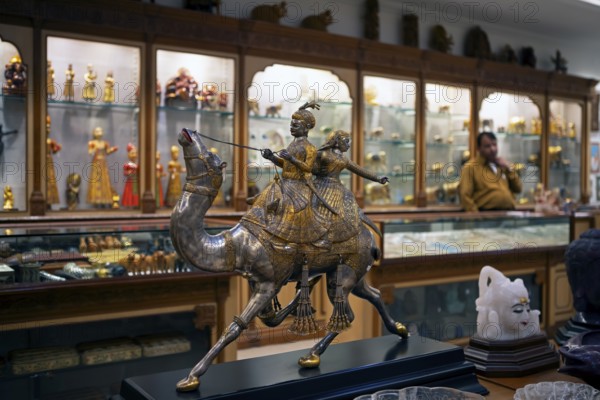 Prince and princess on a silver and gold foil camel in a shop in the old city centre, Jaipur, Rajasthan, India