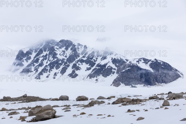 Large boulders in the snow, mountain range, Smeerenburgbreen, Spitsbergen, Svalbard