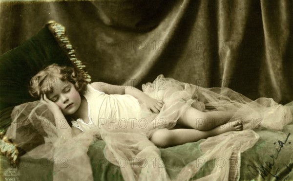 Girl sleeping, 1920, A child sleeping peacefully in a bed with tulle, Historical photo