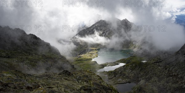 View of mountain landscape with mountain lakes Wangenitzsee and Kreuzsee, cloudy mountain peaks, dramatic atmospheric light, Schober Group, Hohe Tauern National Park, Carinthia, Austria