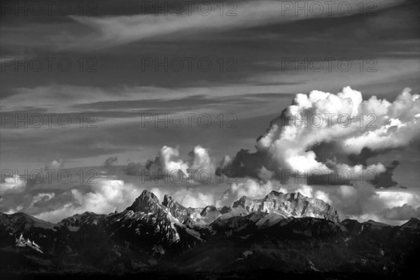 Clouds drift over the striking peaks of the Swiss mountains, showcasing a breathtaking view near Lake Geneva. The landscape highlights nature's beauty and tranquility. Switzerland