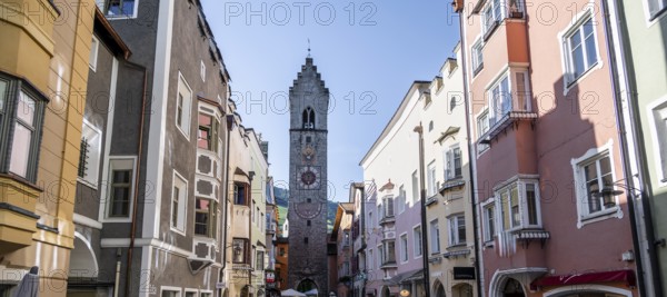 Old town, colourful houses in the main street, Zwölferturm tower at the back, old town, Sterzing, South Tyrol, Italy
