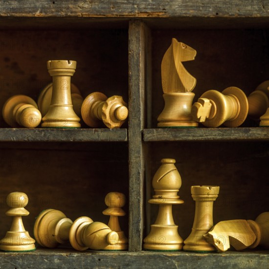 Wooden chess pieces arranged in a vintage box showcasing strategic game elements and craftsmanship