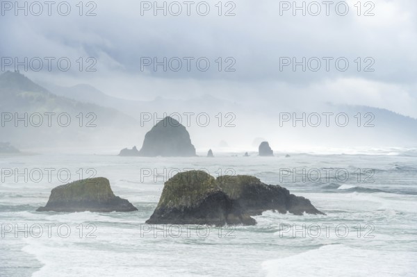 A rugged coastal landscape with rocks in the sea and a cloudy sky, Indian Beach, Oregon, USA, North America
