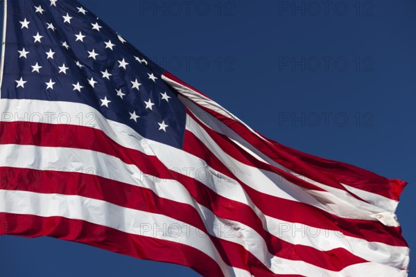 American flag waving in the wind against deep blue sky