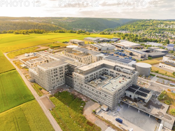 Large industrial complex with multi-storey buildings and surrounding fields and hills, construction of the new hospital Gesundheitscampus Calw, Germany