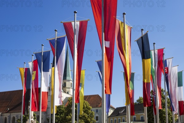 National flags at Kapellplatz with the collegiate parish church of St Philip and St James, place of pilgrimage, Altötting, Upper Bavaria, Bavaria, Germany