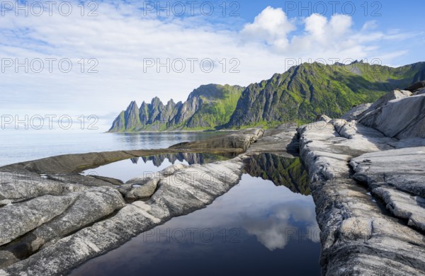 Reflection in a tidal pool, rocky coast of Tungeneset, Devil's Teeth, Okshornan, Ersfjorden, Senja Island, Troms, Norway