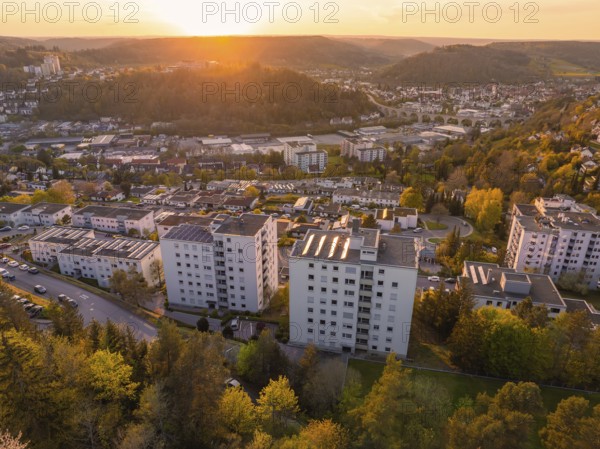 Housing estate with tall buildings and green surroundings at sunset, with a view of the town and hills, Nagold, district of Calw, Germany