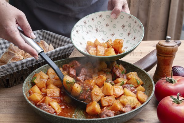 Homemade stew with potatoes and meat, cooked in a frying pan, is served on a plate