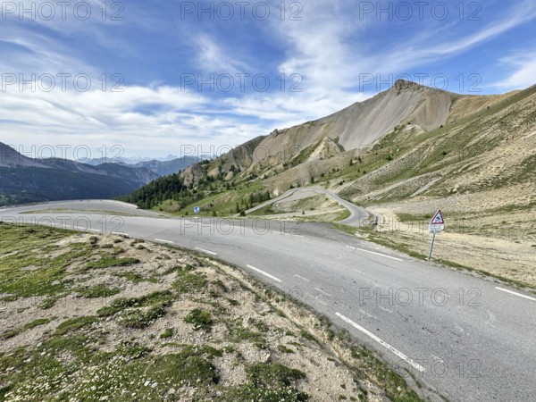Northern ascent mountain road Alpine road with serpentines above tree line shortly in front of the top of the Col d Izoard Alpine pass, Cervières, Alpes-de-Haute-Provence, France