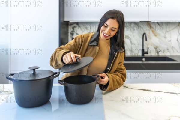 Smiling woman selecting a cooking pot in a bright home improvement store's kitchenware department, enjoying the variety of options available