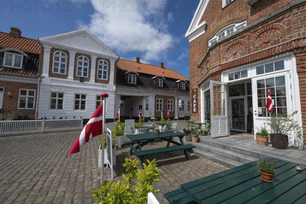 Cosy café with Danish flags and inviting terrace under a blue sky, Old Town, Ringkøbing, Ringkøbing Fjord, Denmark