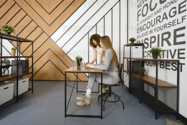 Two women are collaborating on a project in a stylish, modern office designed for a startup focused on women's health