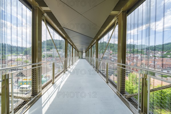 A modern, light-flooded glass corridor with a view of the urban surroundings, Zob extension with bridge construction for the new Herman Hesse railway, Calw, Black Forest, Germany
