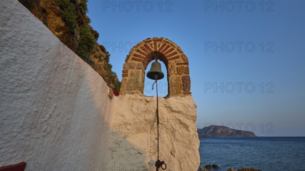 Legend, crab, shell fisherman, stone arch with bell overlooking the sea at sunset, surrounded by rocks and Mediterranean atmosphere, chapel, small church, Agia Kavouradena Monastery, Xirokambos, Leros, Dodecanese, Greek Islands, Greece