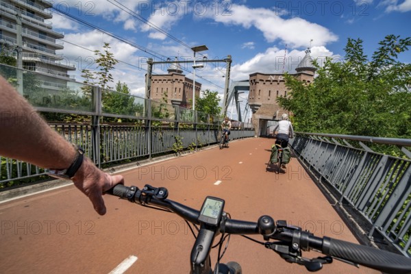 Ride over the Snelbinder Brug bicycle and pedestrian bridge, over the river Waal near Nijmegen, was built on the existing railway bridge, fast cycle path connection from the city centre of Nijmegen and the new housing estates in the Waalsprong district, Netherlands