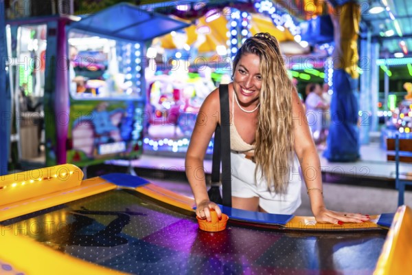 Happy tourist enjoying an exciting air hockey game in a vibrant luna park, experiencing fun and laughter during summer vacation nights