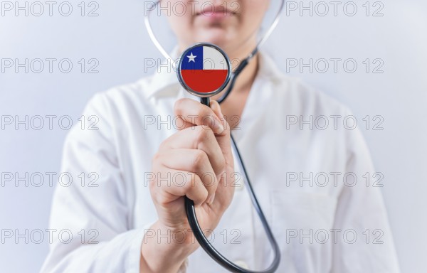 Female doctor holding stethoscope with Chile flag. National health system of Chile