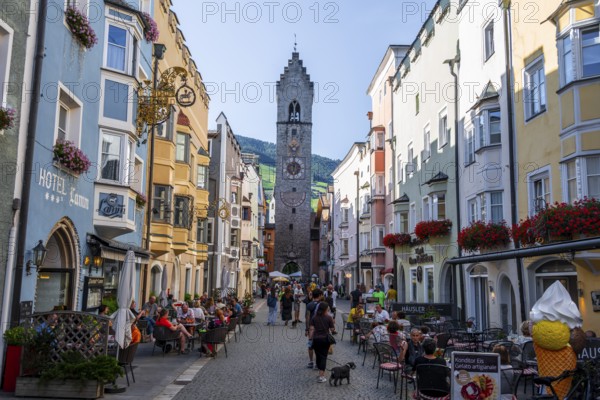 Old town, colourful houses in the main street, Zwölferturm tower at the back, old town, Sterzing, South Tyrol, Italy