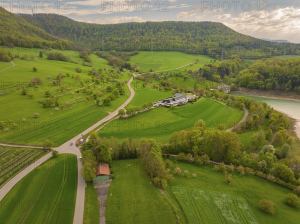 Green landscape with meadows and fields around a building on a hill, Glems reservoir, Swabian Alb, Germany