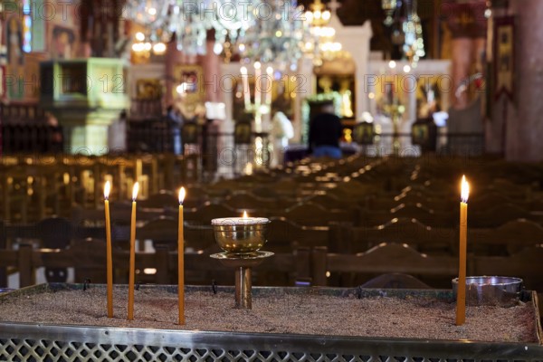 Burning candles on a sand container in an illuminated church with blurred surroundings, Church of the Annunciation of the Blessed Virgin Mary, Rhodes Town, Greece, Orthodox Church, Dodecanese, Greek Islands, Rhodes Town, Holy Week, Rhodes
