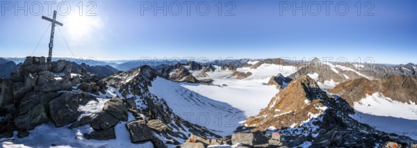 Mountain panorama at the Wilder Freiger summit with summit cross, picturesque high mountain landscape with snow, view of the Übeltalferner glacier and rocky mountain peaks Königshofspitz and Sonklarspitze, Wilder Pfaff and Ruderhofspitze, Stubai Alps, South Tyrol, Italy